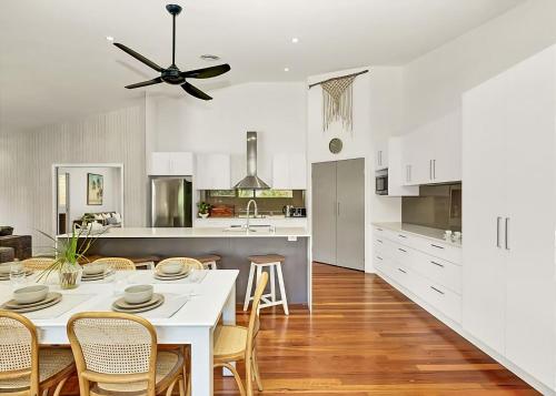 a kitchen and dining room with a table and chairs at McCabe Coffs Retreat in Coffs Harbour