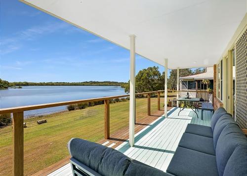 a deck with a couch and a view of the water at The Tides in Urunga
