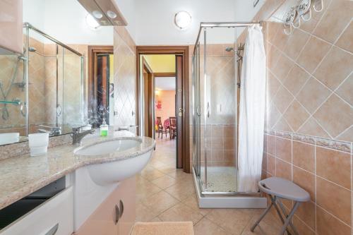 y baño con lavabo y ducha. en Villetta Bacio del Sole, en Sinnai