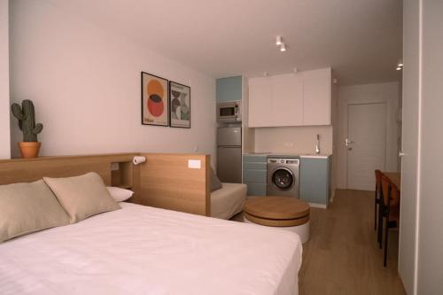 1 dormitorio pequeño con 1 cama y cocina en Spectacular renovated studio facing the sea, en Valencia