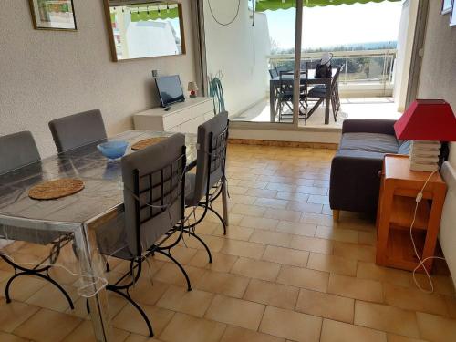 un salon avec une table, des chaises et un canapé dans l'établissement Spacieux appartement avec terrasse, parking privé, et vue sur la mer - FR-1-716-37, à La Grande Motte