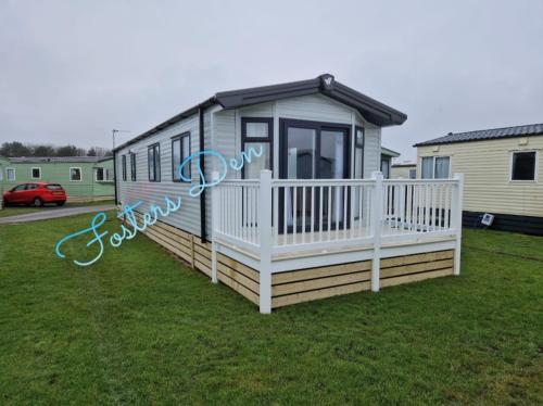 a tiny house with a porch and a fence at Q8 ocean edge caravan park in Heysham