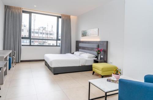 a bedroom with a bed and a living room at Liv Weibdeh Hotel Suites in Amman