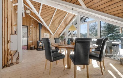 a dining room with a wooden table and black chairs at 3 Bedroom Stunning Home In Fjerritslev in Fjerritslev