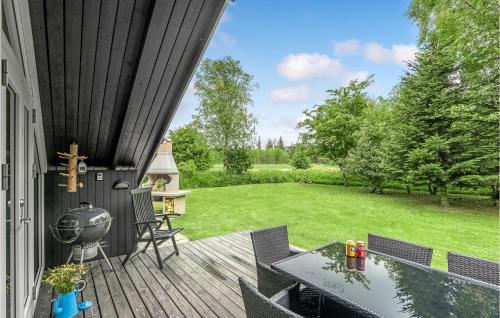 an outdoor deck with a grill and a lawn at 3 Bedroom Stunning Home In Fjerritslev in Fjerritslev