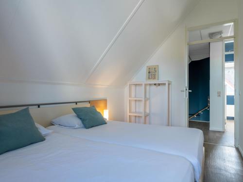 1 dormitorio con 1 cama blanca y 2 almohadas en Antibes 234 - Kustpark Village Scaldia, en Hoofdplaat