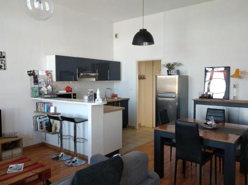 un salon avec une cuisine et une table avec une salle à manger dans l'établissement Appartement de charme bord de Loire, à Saumur
