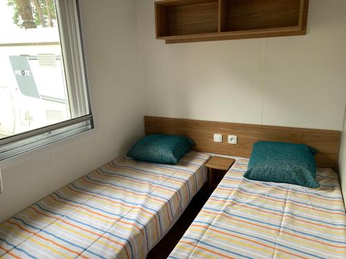 Cette chambre comprend 2 lits et une fenêtre. dans l'établissement RESPIRE, à Quiberon