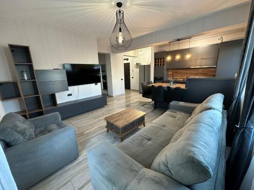 sala de estar amplia con sofá y mesa en Apartament Ella C&C Residence, en Mamaia Nord – Năvodari