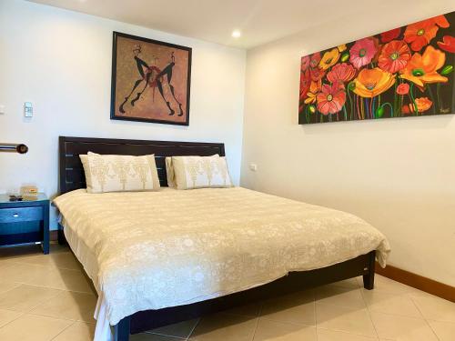 a bedroom with a bed and a painting on the wall at Andaman Hill Pool Seaview in Patong Beach