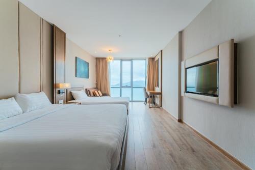 a hotel room with two beds and a flat screen tv at SeaHaven Panorama Nha Trang Superview Apartments in Nha Trang