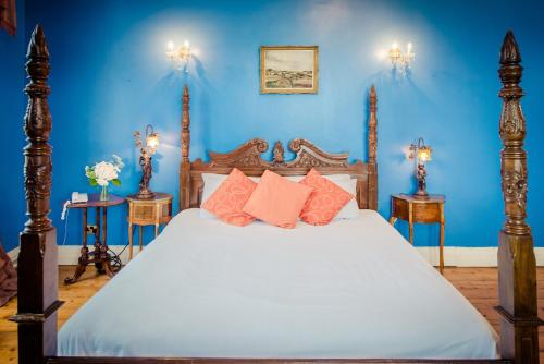 a blue bedroom with a bed with orange pillows at Kinnitty Castle Hotel in Kinnitty
