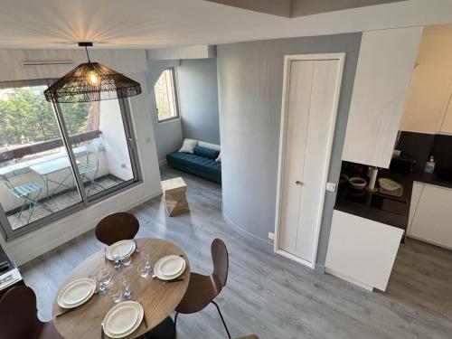 un salon avec une table et des chaises et une cuisine dans l'établissement Cabourg: Duplex Rénové 2P, Plage Directe, Fibre - FR-1-487-351, à Cabourg