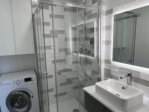 une salle de bain avec une machine à laver et un lavabo dans l'établissement Cabourg: Duplex Rénové 2P, Plage Directe, Fibre - FR-1-487-351, à Cabourg