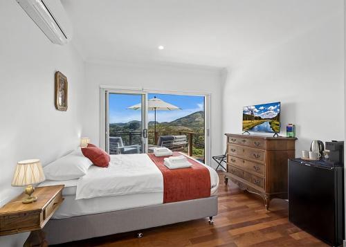 a bedroom with a bed and a dresser and a window at Ciao Korora The Classic in Kororo Basin