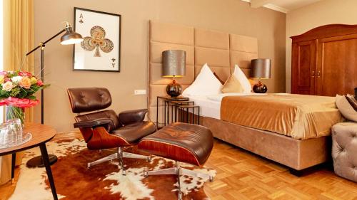 クサンテンにあるHotel van Bebberのベッドと椅子のあるホテルの部屋