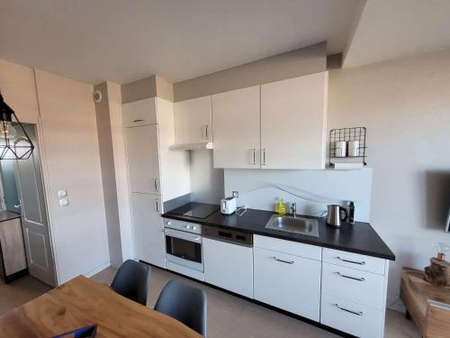 - une cuisine avec des placards blancs, un évier et une table dans l'établissement Studio avec Balcon, Parking Privatif et Wi-Fi à Wimereux - FR-1-675-20, à Wimereux