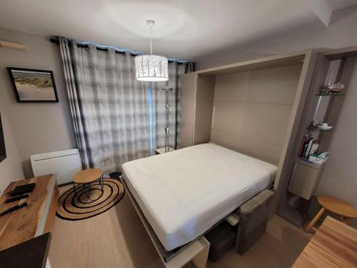 une petite chambre avec un lit et un bureau dans l'établissement Studio avec Balcon, Parking Privatif et Wi-Fi à Wimereux - FR-1-675-20, à Wimereux