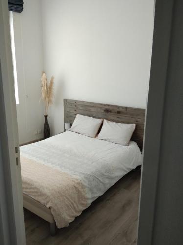 une chambre avec un lit avec des draps blancs et des oreillers dans l'établissement Appartement de charme bord de Loire, à Saumur