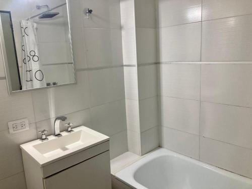 a white bathroom with a sink and a bath tub at 6-Maravilloso departamento morón centro in Morón