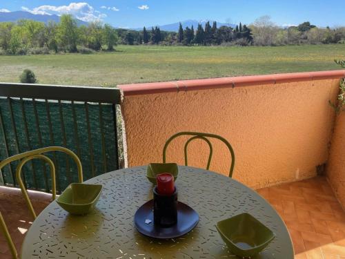 - une table sur un balcon avec vue sur un champ dans l'établissement Appartement 2 pièces à Argelès-sur-Mer, 300m de la plage, terrasse, parking, animaux acceptés - FR-1-225-771, à Argelès-sur-Mer