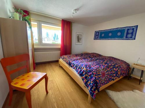 Schlafzimmer mit einem Bett, einem Tisch und einem Fenster in der Unterkunft Bärgblick in Schwarzsee