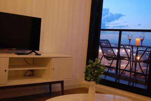 uma sala de estar com televisão e uma janela com varanda em Apartamento nuevo, centrico y con vista a la bahia em Montevidéu