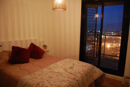 a bedroom with a bed and a window with a view at Apartamento nuevo, centrico y con vista a la bahia in Montevideo