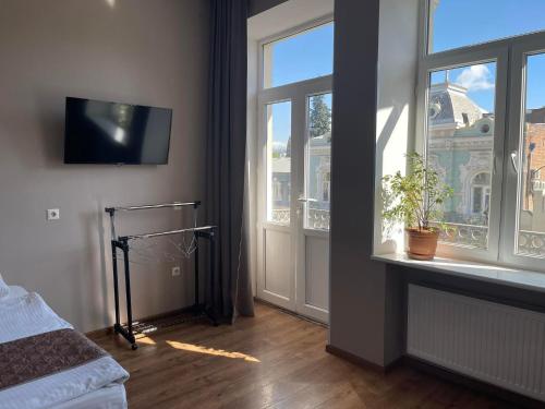 a bedroom with a window and a tv on the wall at Aparthotel Old Avenue in Tbilisi City