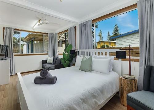 a bedroom with a large white bed and a balcony at Nonna and Pops in Mylestom