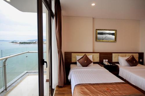 a hotel room with two beds and a balcony at Lenid Ocean View Hotel in Nha Trang