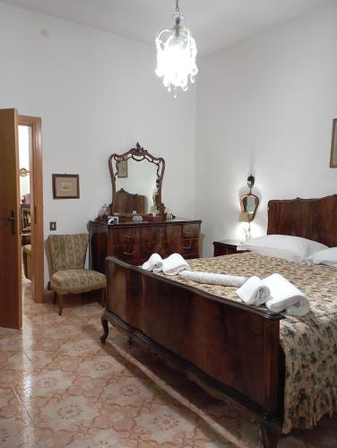 una camera con letto, cassettiera e specchio di Casa San Carlo Affittacamere Foligno a Foligno