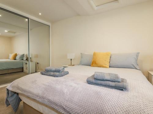 een slaapkamer met een groot bed en handdoeken bij Falcon House in Tintagel