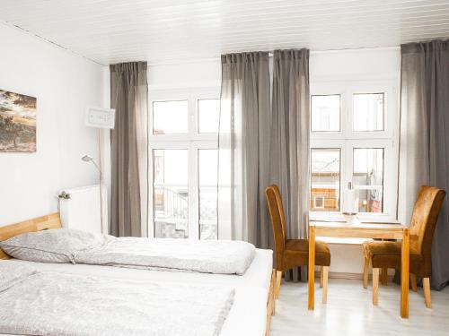 ein Schlafzimmer mit zwei Betten und einem Schreibtisch und einem Tisch in der Unterkunft Ferienwohnungen Merl in Zell an der Mosel