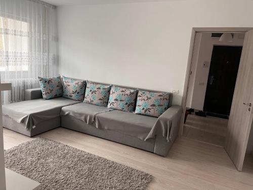 a living room with a gray couch with blue pillows at Apartament 2 camere in Bucharest