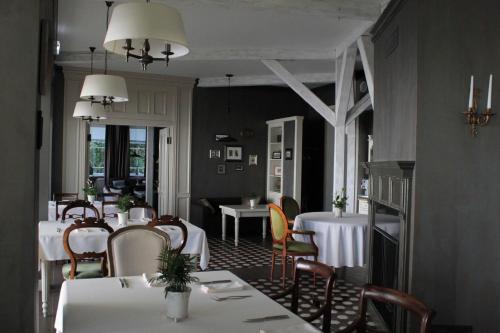 a dining room with white tables and chairs at Villa Joma in Jūrmala