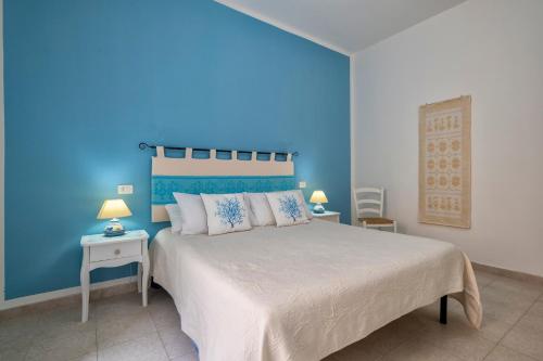 a blue bedroom with a bed and a blue wall at Casa Vacanze San Michele in Alghero