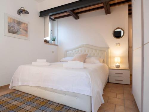 een witte slaapkamer met een wit bed en een raam bij City Center “Casa Giuliana” in Perugia