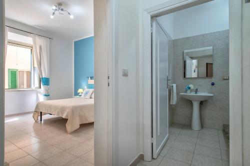 Casa Vacanze San Michele في ألغيرو: حمام مع سرير ومغسلة في الغرفة