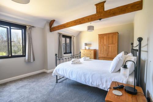 ein Schlafzimmer mit einem großen Bett und einem Holztisch in der Unterkunft Ware Barn Cottage in Lyme Regis