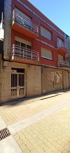 un aparcamiento vacío frente a un edificio en Apartamentos nova de abaixo 3, 1B 1A y 1D, en Pontevedra
