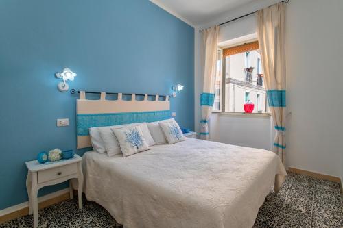 a blue bedroom with a bed and a window at Casa Vacanze San Michele in Alghero
