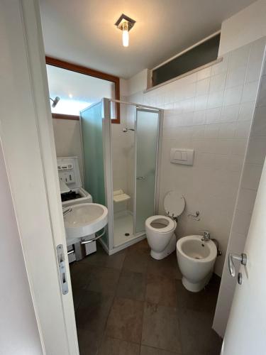 bagno con 2 servizi igienici, doccia e lavandino di Appartamento in centro con terrazze e parcheggio gratuito a Lignano Sabbiadoro