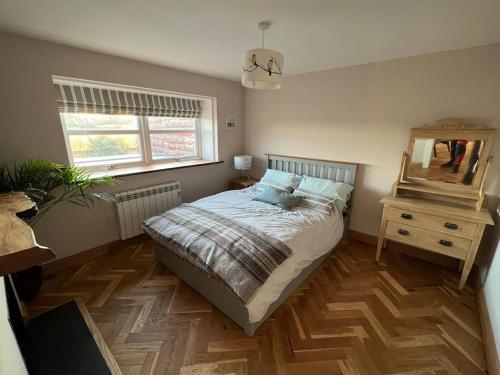 a bedroom with a bed and a dresser and a mirror at Osprey Hide in Forres