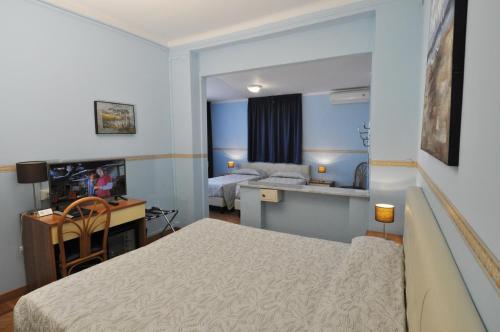 サンレモにあるホテル ソーレ マーレのベッド1台、デスク、ベッドルーム1室が備わります。