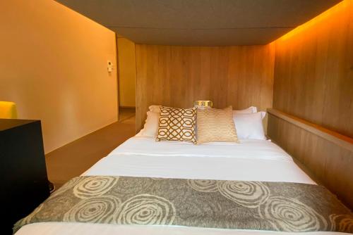 una camera da letto con un grande letto con cuscini sopra di ST Signature Tanjong Pagar, DAYUSE, 8 hours, 10AM-6PM a Singapore