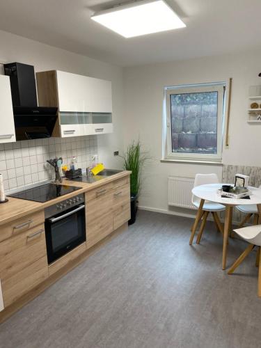 a kitchen with wooden cabinets and a table and a dining room at Apartment im Grünen bei Koblenz in Vallendar