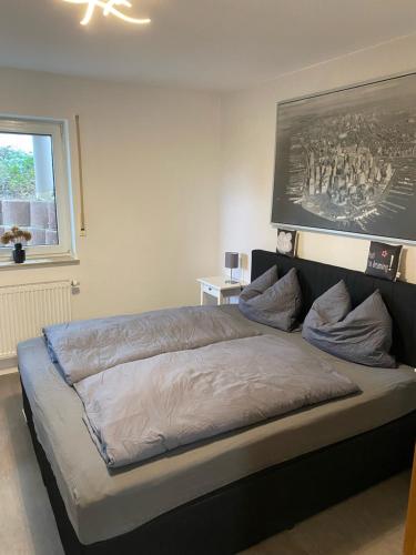 a bedroom with a large bed with a picture on the wall at Apartment im Grünen bei Koblenz in Vallendar