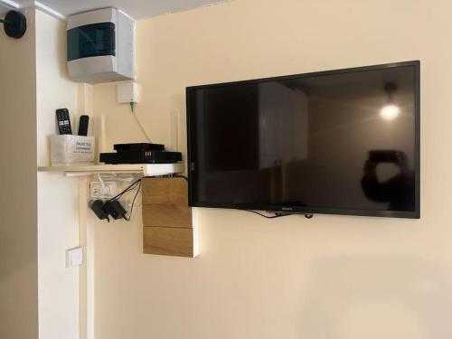 a flat screen tv hanging on a wall at Charm'in Champigny: Studio cosy, détente & travail in Champigny-sur-Marne
