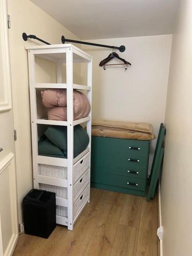 une chambre avec une étagère blanche et un lit dans l'établissement Charm'in Champigny: Studio cosy, détente & travail, à Champigny-sur-Marne